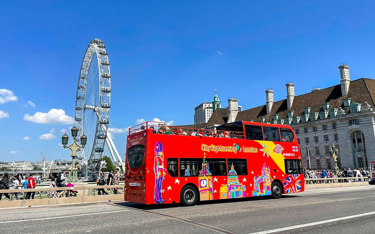 Red double-decker bus near the London Eye on the Thames River cruise tour.