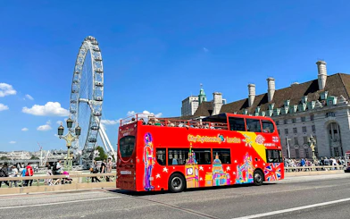Red double-decker bus near the London Eye on the Thames River cruise tour.