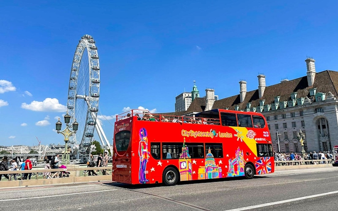 Red double-decker bus near the London Eye on the Thames River cruise tour.