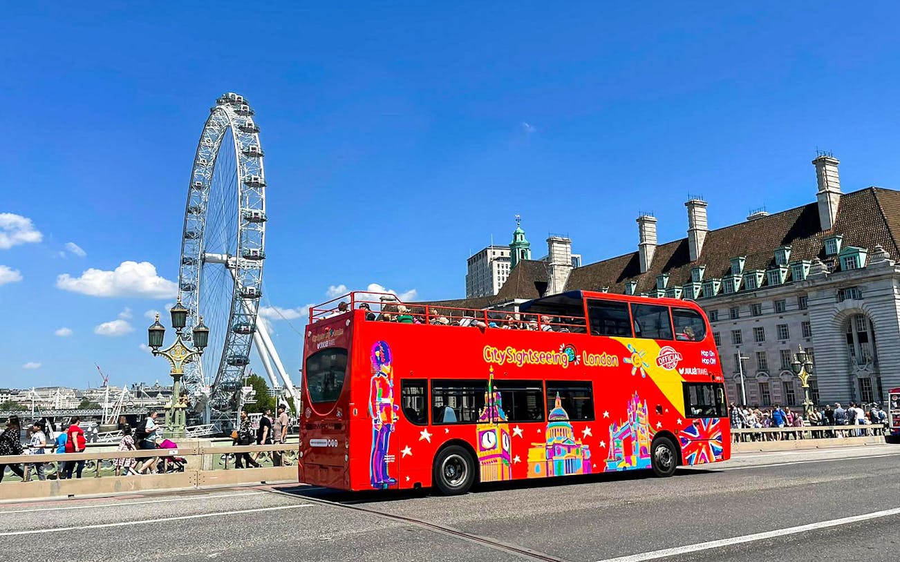 Red double-decker bus near the London Eye on the Thames River cruise tour.
