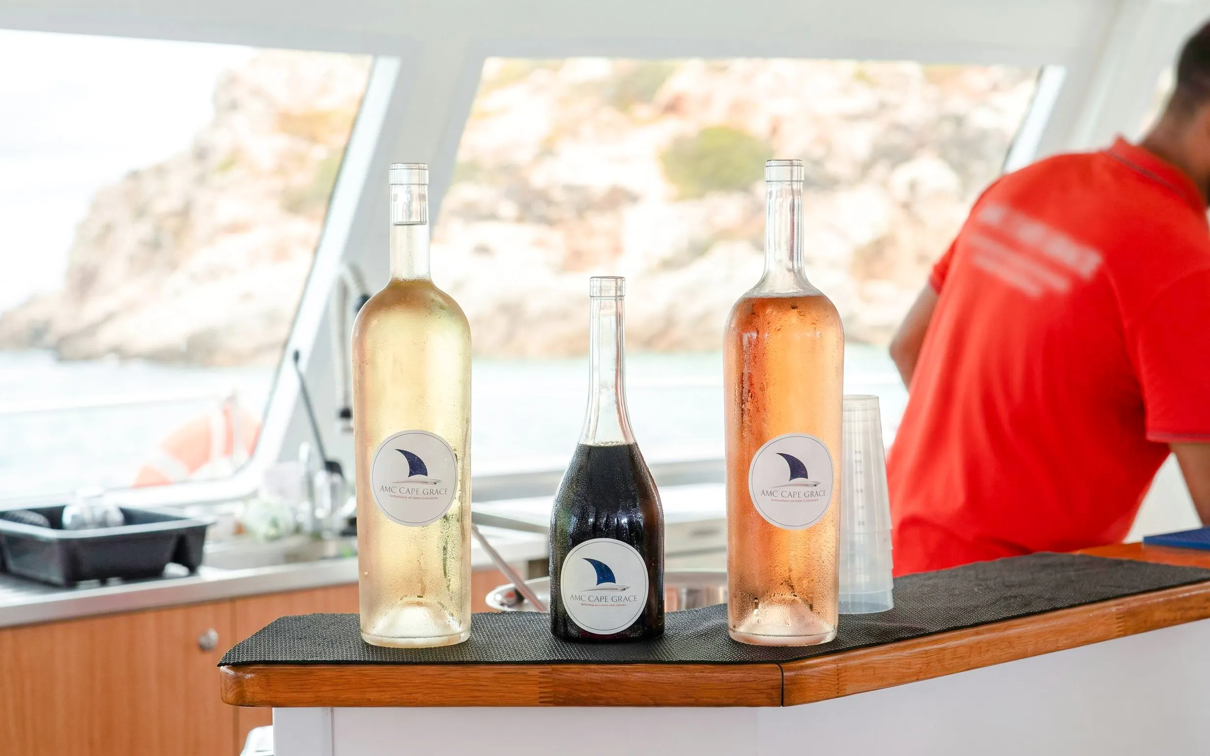 Bottles of wine on a catamaran bar during Lérins Island cruise, Marina Bay of Angels.
