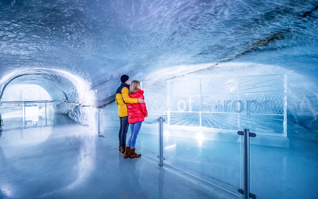 Couple exploring Ice Palace at Jungfraujoch, Switzerland.