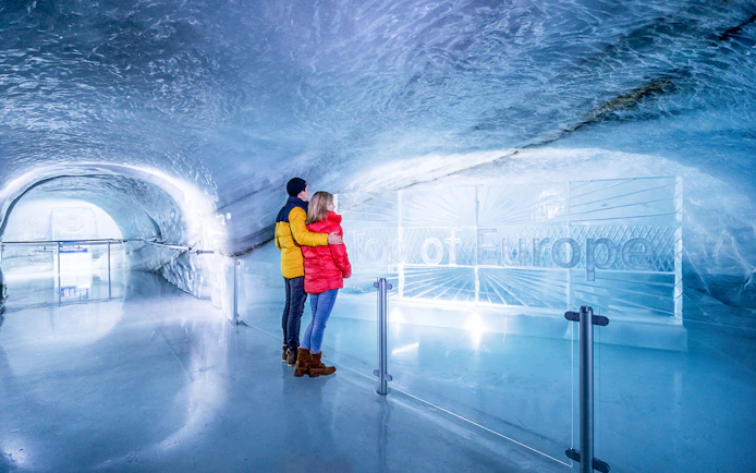 Couple exploring Ice Palace at Jungfraujoch, Switzerland.