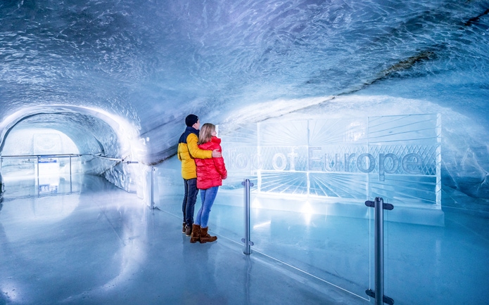 Couple exploring Ice Palace at Jungfraujoch, Switzerland.