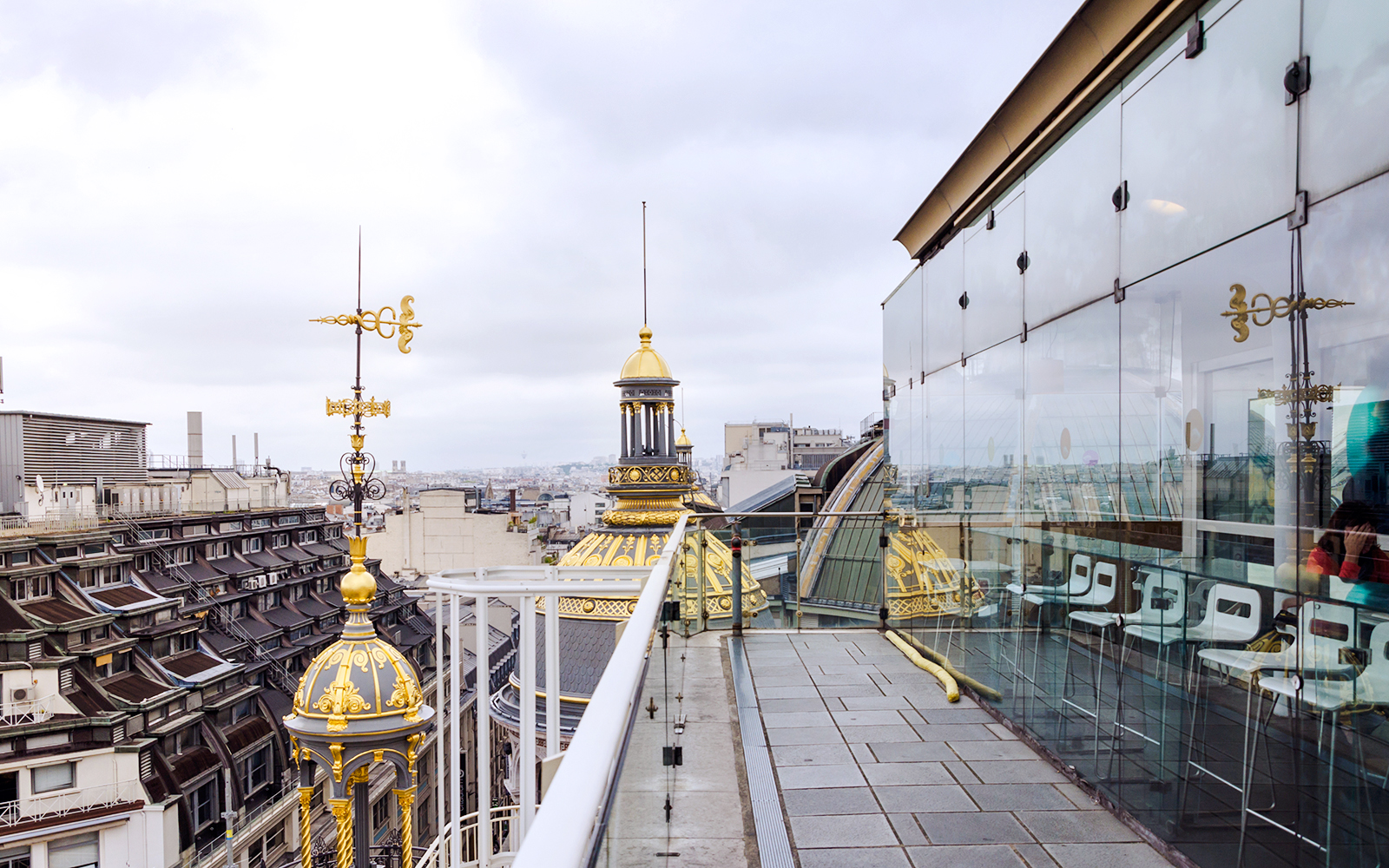 Rooftop view from Printemps Haussmann in Paris with ornate golden domes and cityscape.