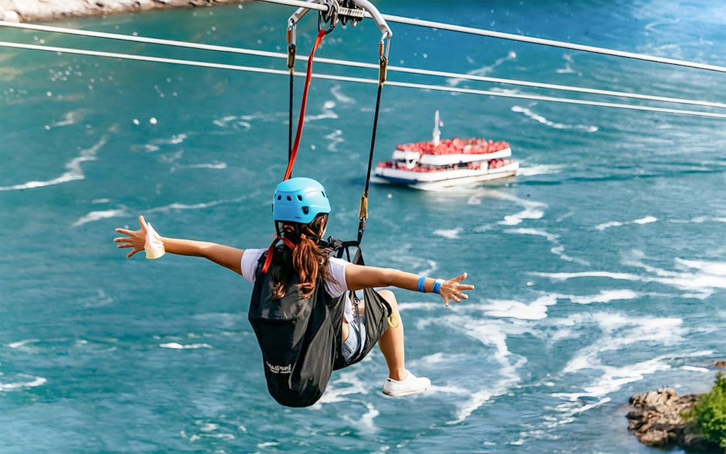 Person ziplining over water with a boat below at Niagara Falls.