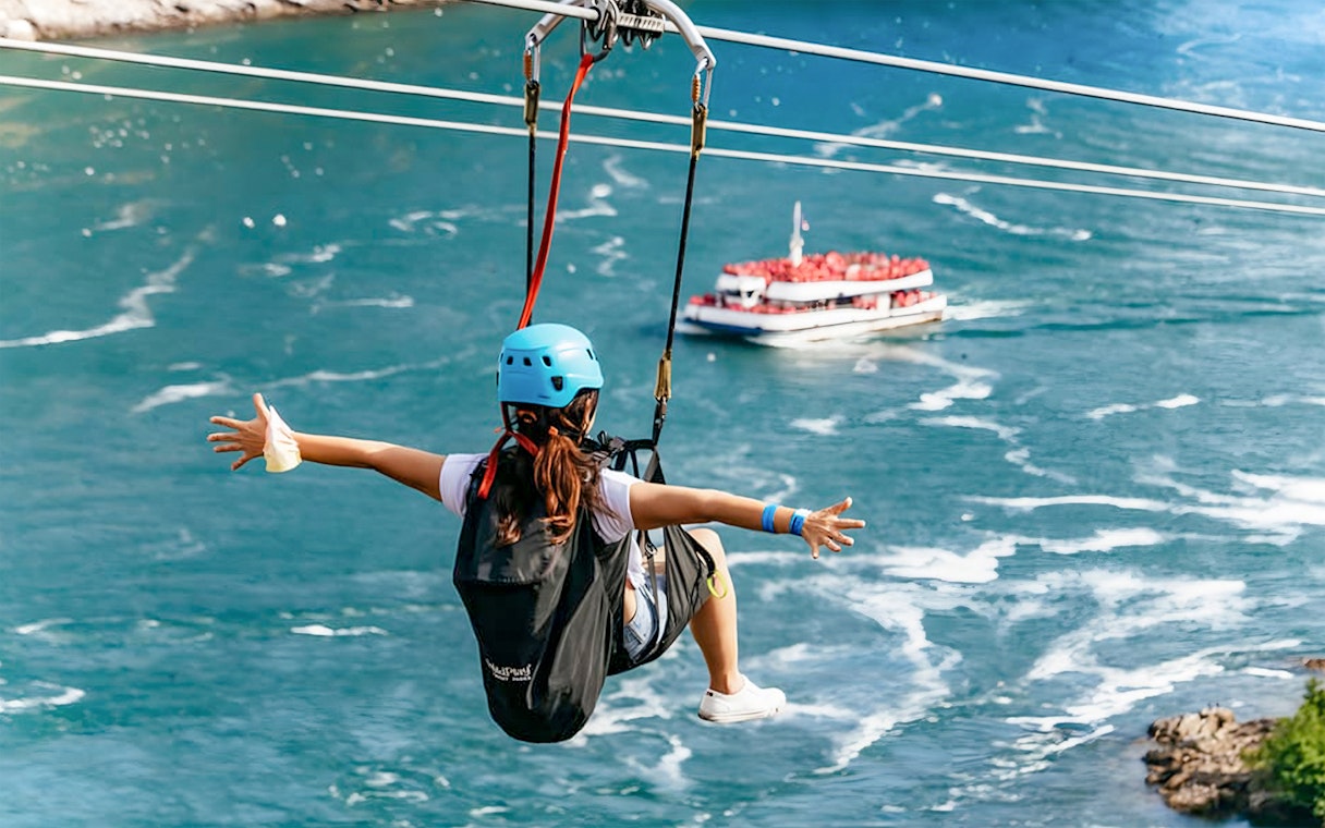 Person ziplining over water with a boat below at Niagara Falls.