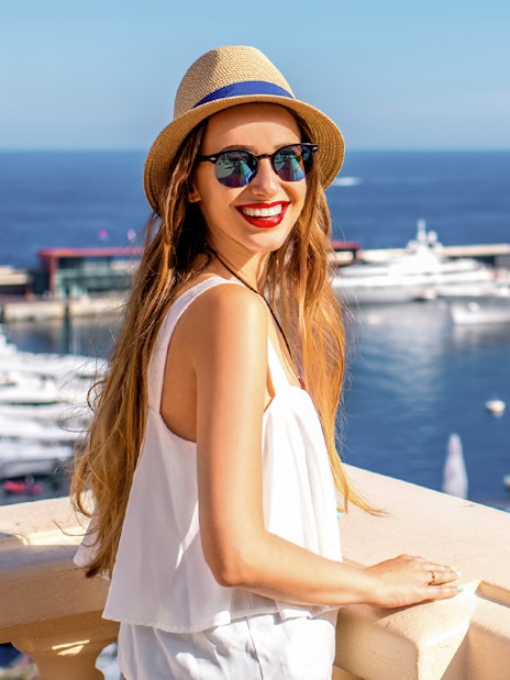 Woman enjoying view of yachts in Monte Carlo harbor, Italian Riviera and Monaco tour.