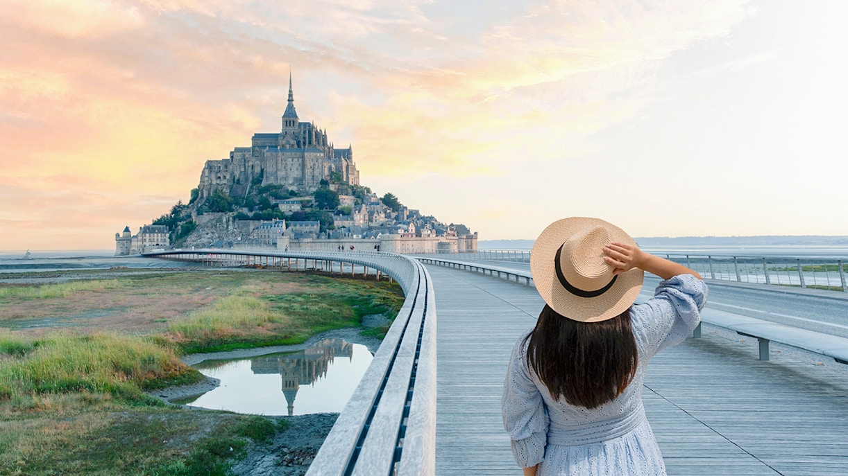 Woman walking on the pathway to Mont Saint Michel, Normandy, France.