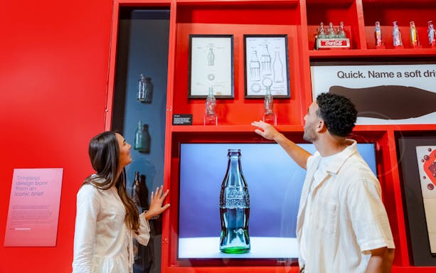 Couple examining Coca-Cola bottle designs at World of Coca-Cola, Atlanta.