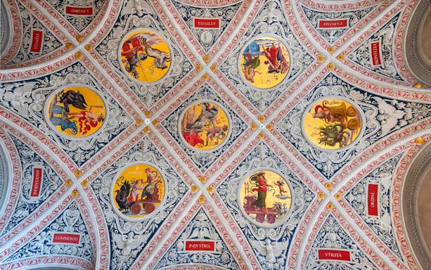 Ceiling frescoes at Palazzo delle Papesse, Siena, featuring intricate circular paintings.