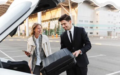 Man loading suitcase into car trunk at Luxor hotel for transfer to Hurghada hotel.