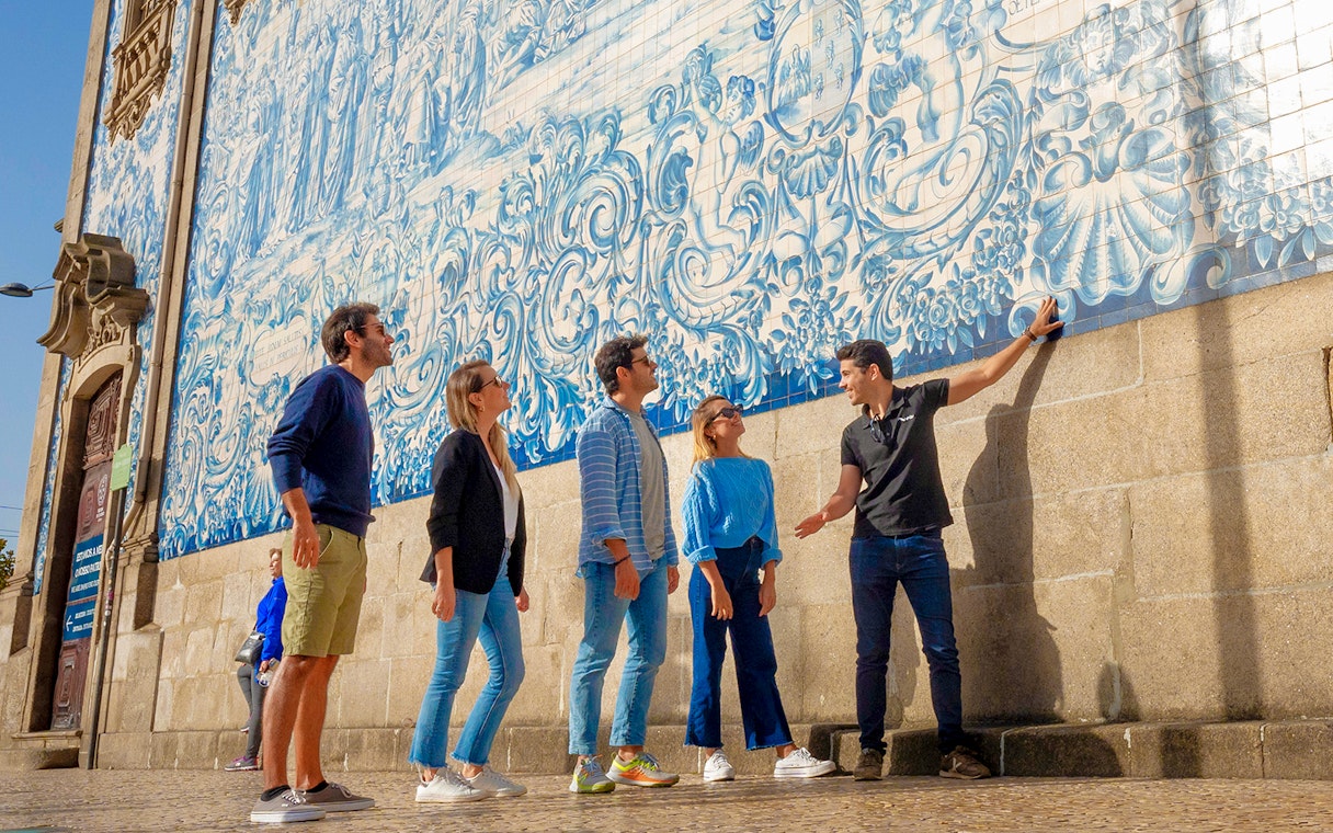 Tourists with guide admiring azulejo tiles on Porto walking tour.