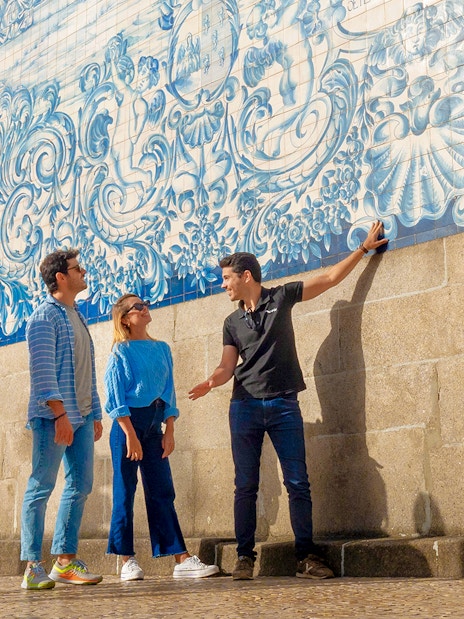 Tourists with guide admiring azulejo tiles on Porto walking tour.