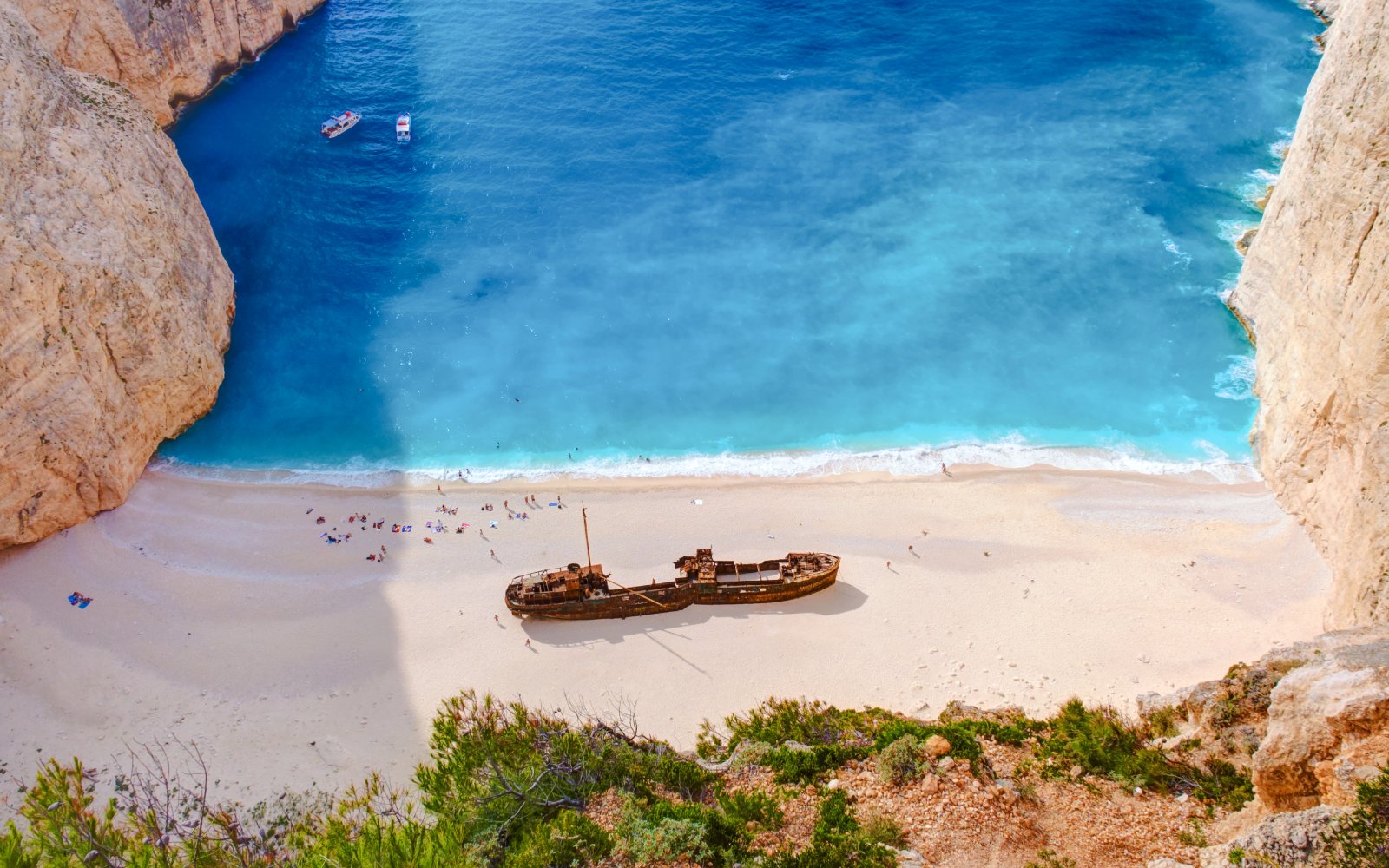 Shipwreck Beach in Zakynthos with shipwreck on sandy shore and turquoise water.