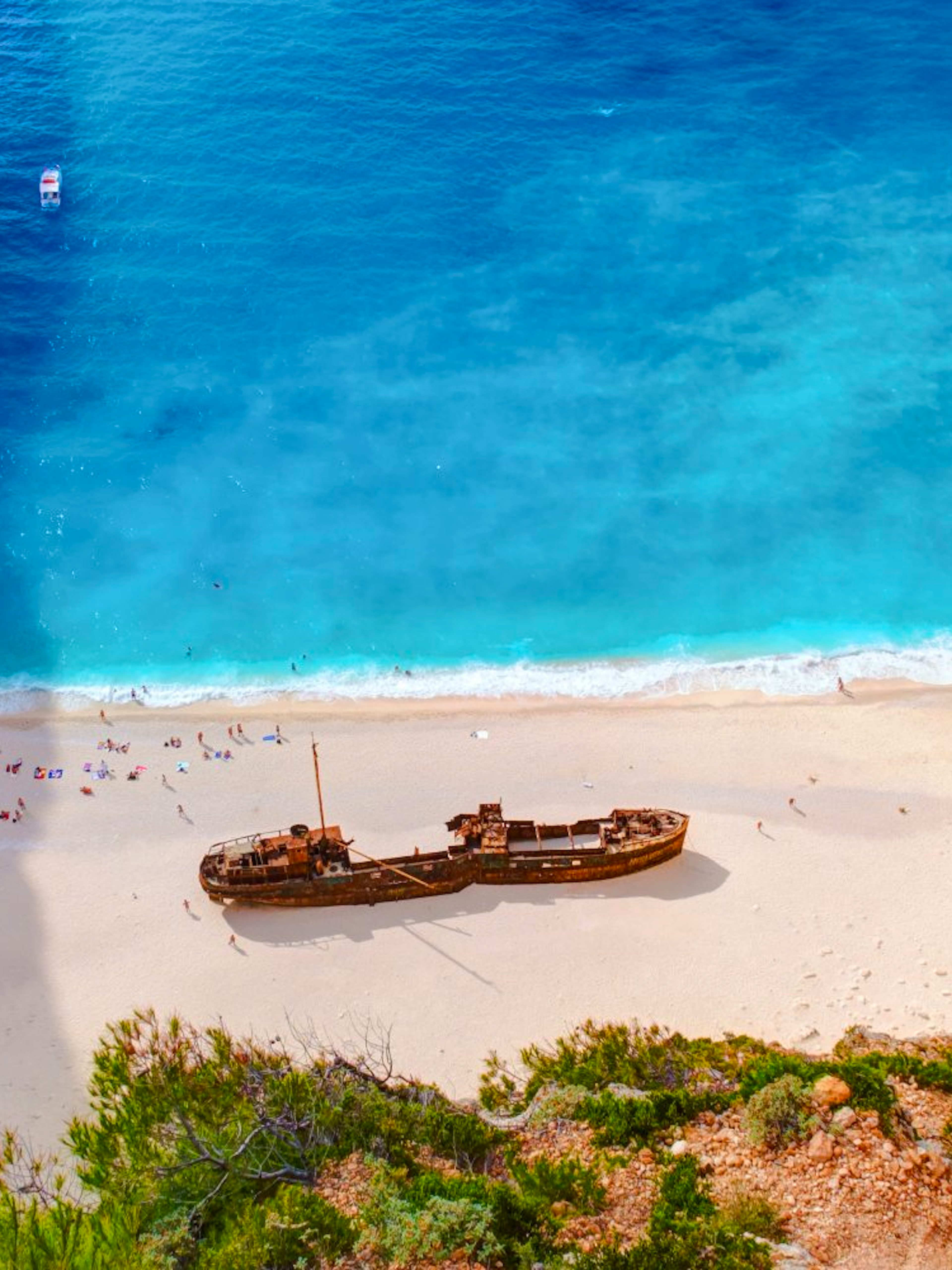 Shipwreck Beach in Zakynthos with shipwreck on sandy shore and turquoise water.