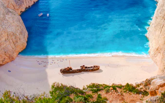 Shipwreck Beach in Zakynthos with shipwreck on sandy shore and turquoise water.