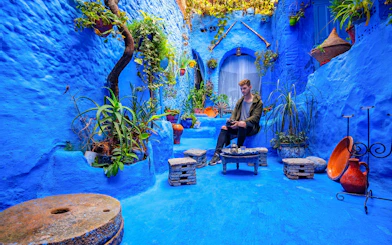 Courtyard with blue walls and plants in the medina of Chefchaouen, Morocco.