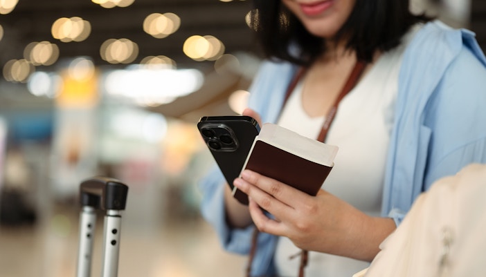 women checking her flight ticket on phone