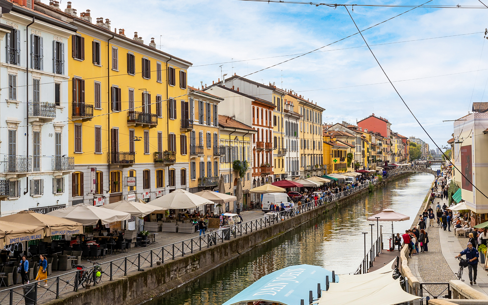 Milan canal with boats and historic buildings in the background.