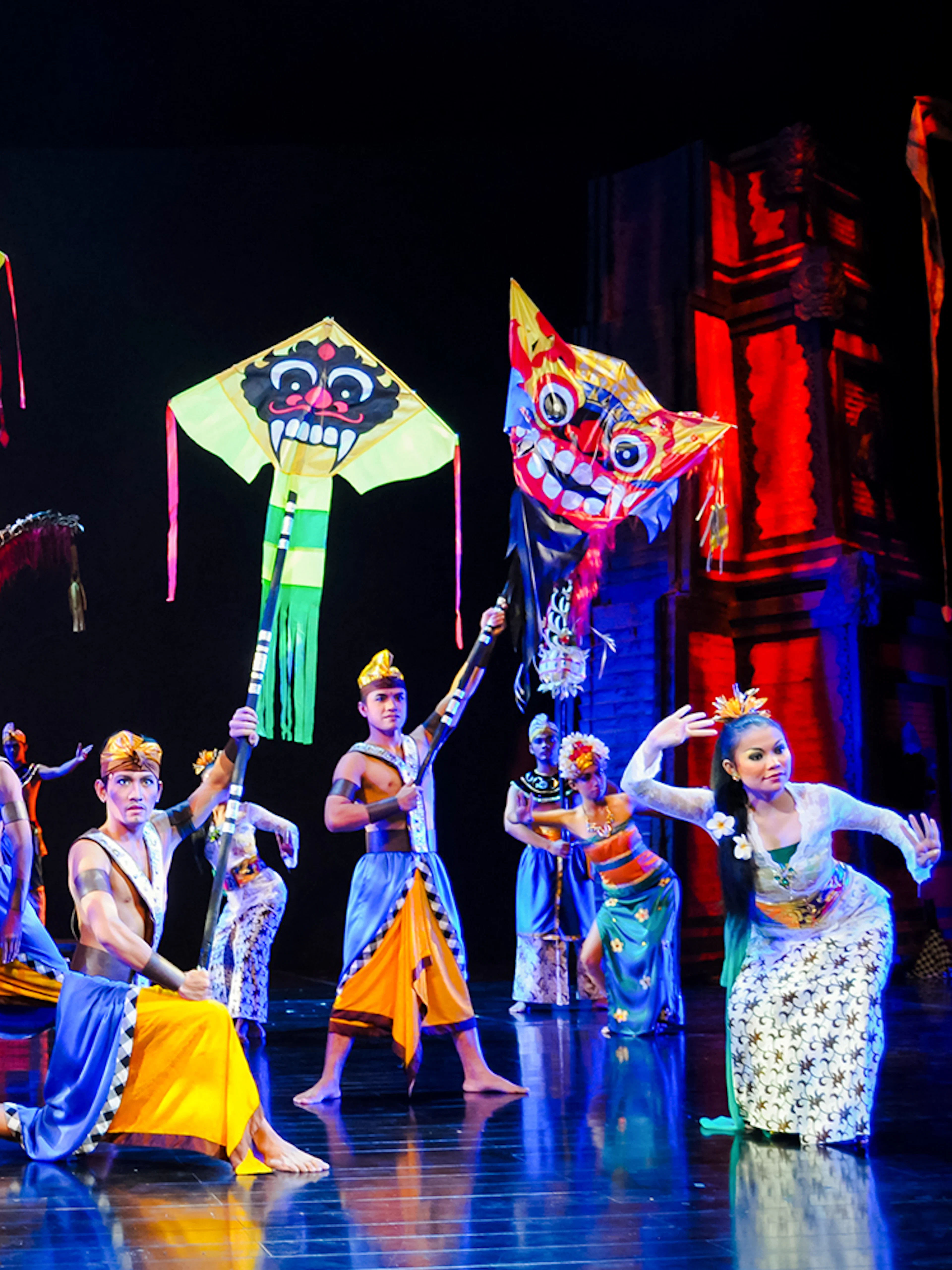 Performers on stage during the Devdan Show in Bali with colorful kites.