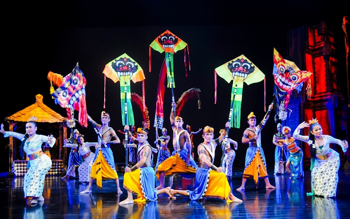 Performers on stage during the Devdan Show in Bali with colorful kites.