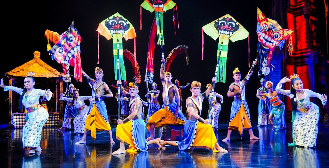 Performers on stage during the Devdan Show in Bali with colorful kites.