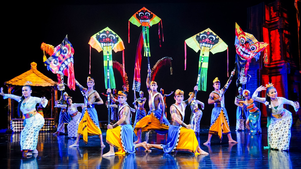 Performers on stage during the Devdan Show in Bali with colorful kites.
