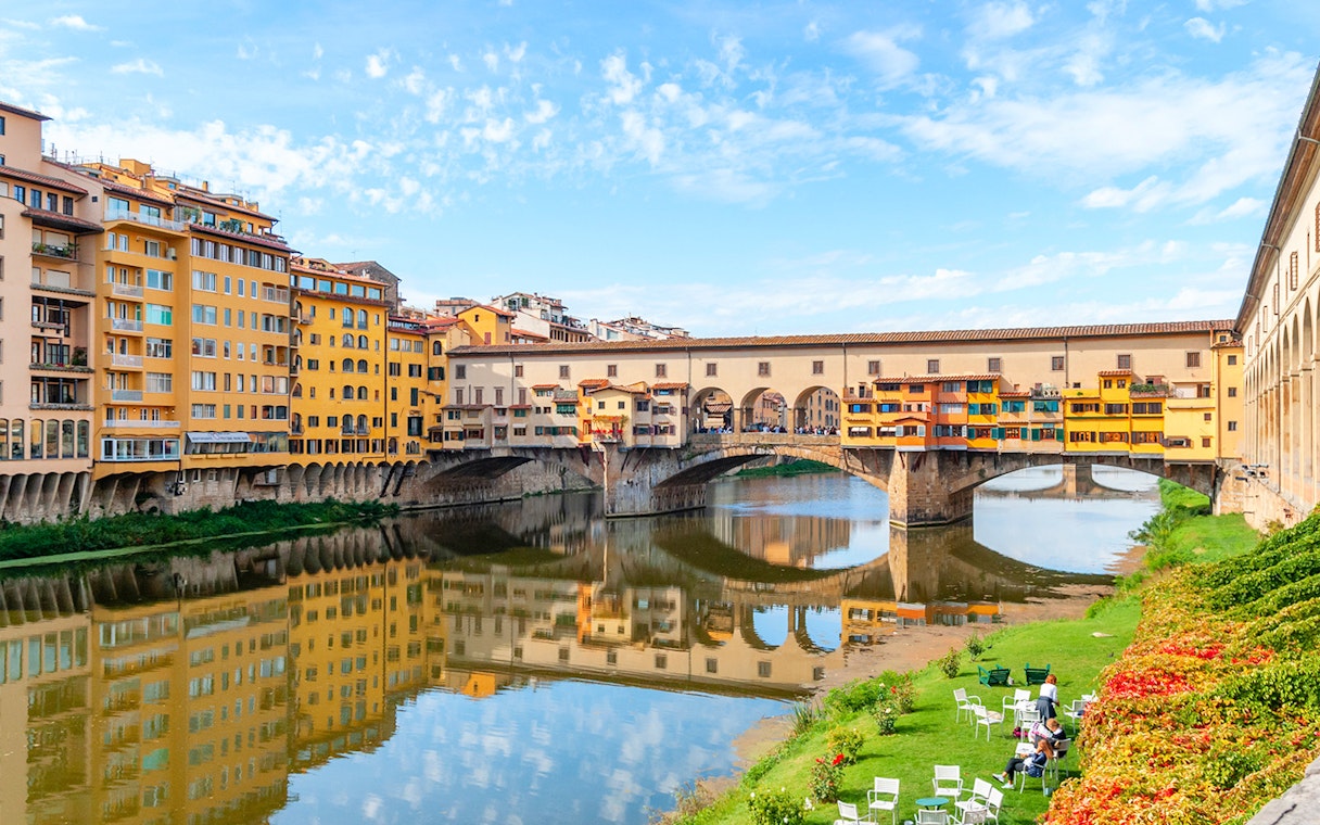 Ponte Vecchio bridge over the Arno River in Florence, Italy, with colorful buildings.