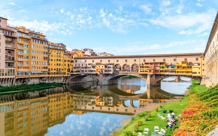 Ponte Vecchio bridge over the Arno River in Florence, Italy, with colorful buildings.