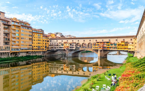 Ponte Vecchio bridge over the Arno River in Florence, Italy, with colorful buildings.