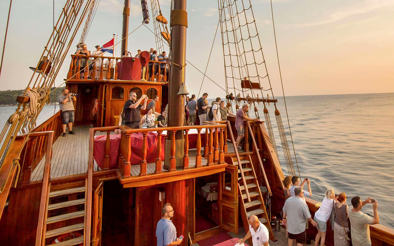 Guests on Karaka Ship enjoying sunset views during a cruise.