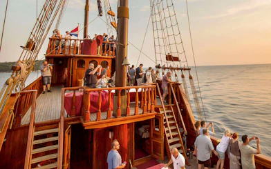 Guests on Karaka Ship enjoying sunset views during a cruise.