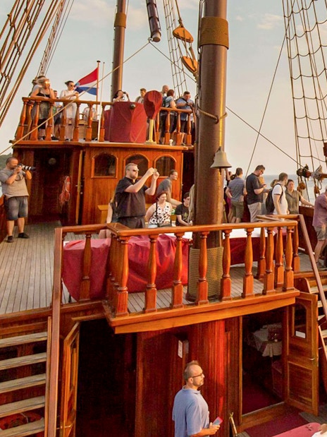 Guests on Karaka Ship enjoying sunset views during a cruise.