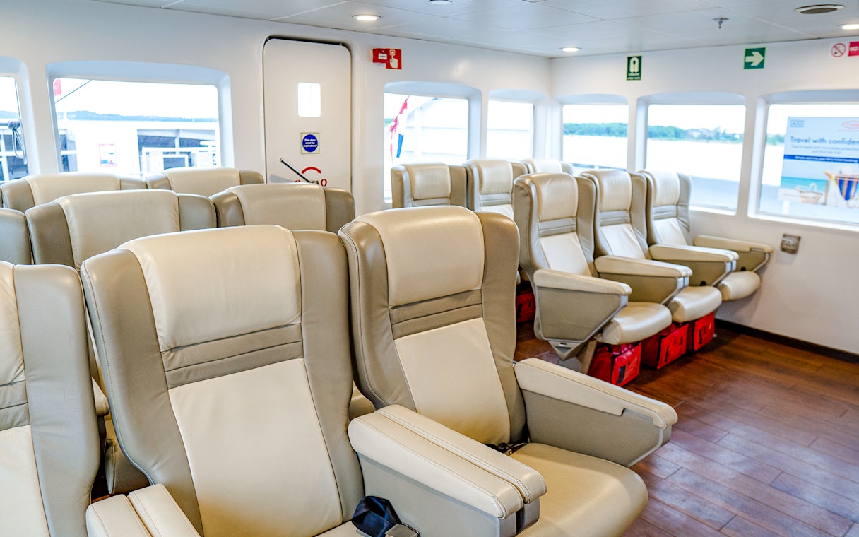Ferry interior with rows of beige seats on the Singapore to Batam route.
