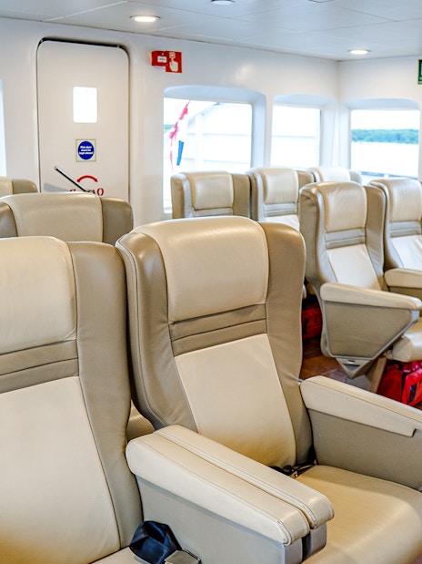 Ferry interior with rows of beige seats on the Singapore to Batam route.