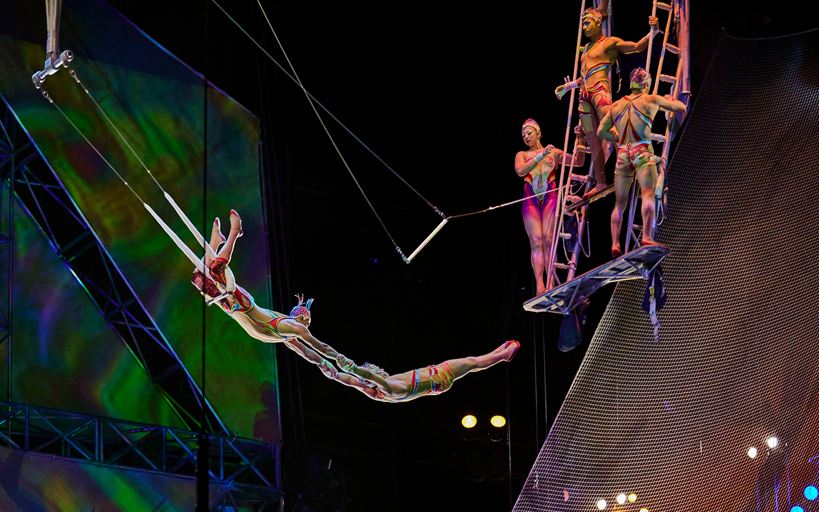 Acrobats performing a trapeze act in Mystère show.