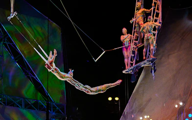 Acrobats performing a trapeze act in Mystère show.