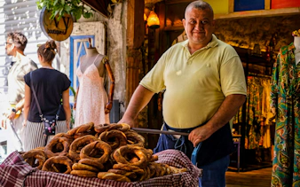 Man selling simit on Istanbul street during food tour.