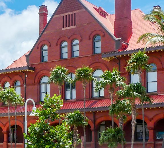 St. Augustine History Museum red brick building with palm trees in front.