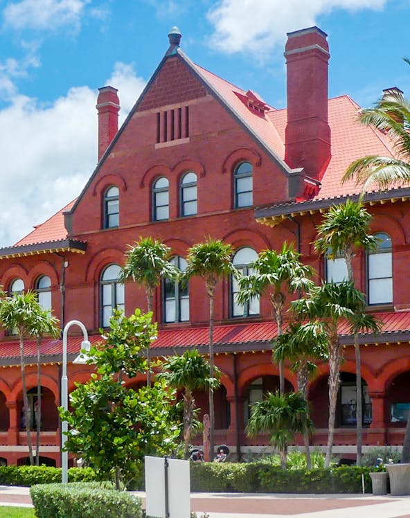 St. Augustine History Museum red brick building with palm trees in front.