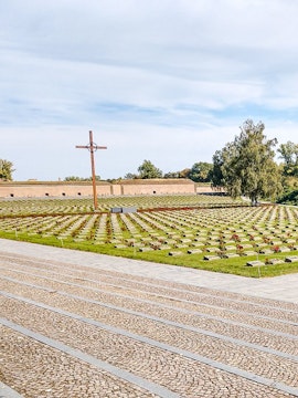 Terezin Concentration Camp cemetery with cross and rows of graves.