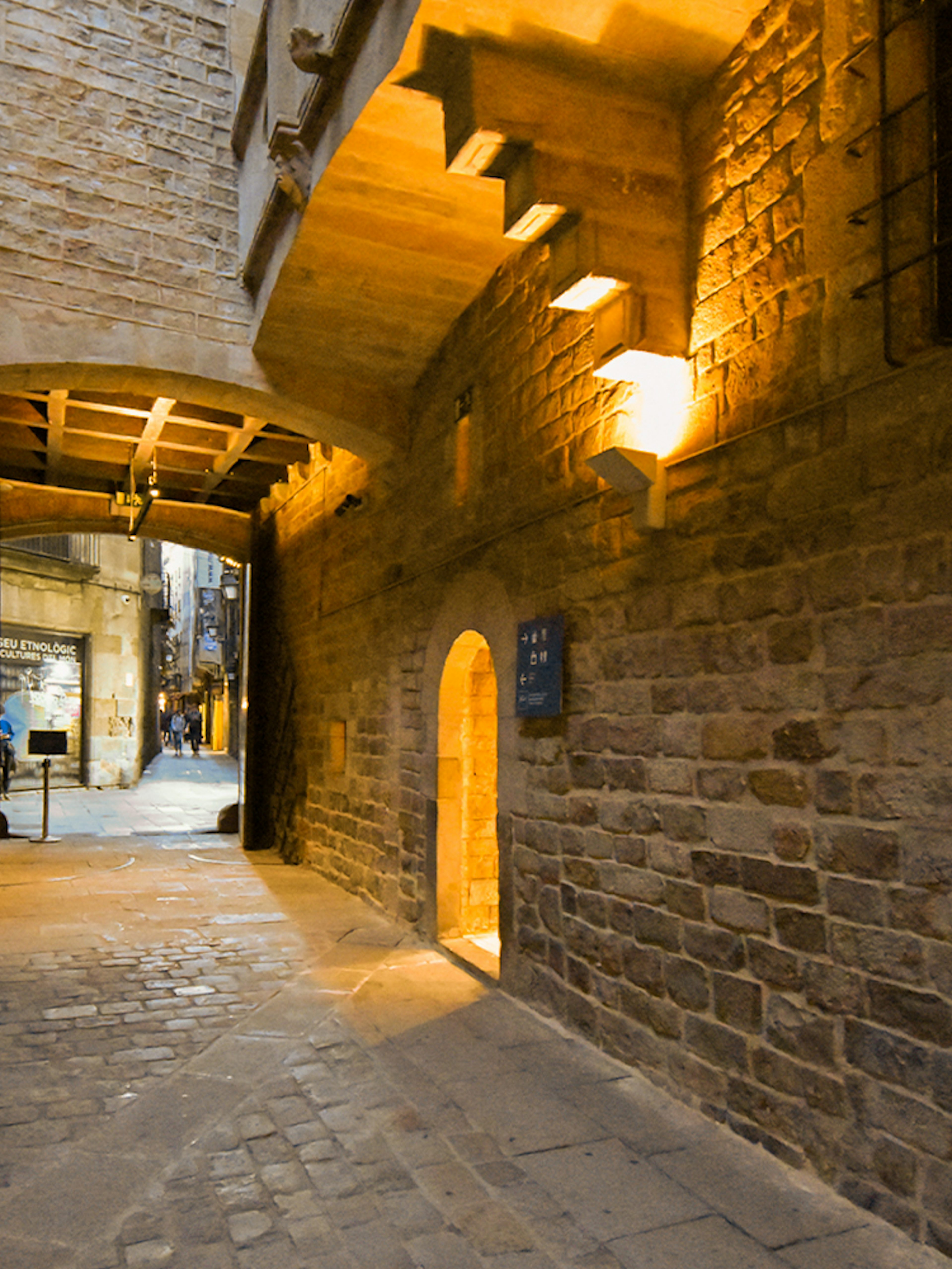 Entrance to the Picasso Museum in Barcelona, featuring a stone archway and cobblestone path.