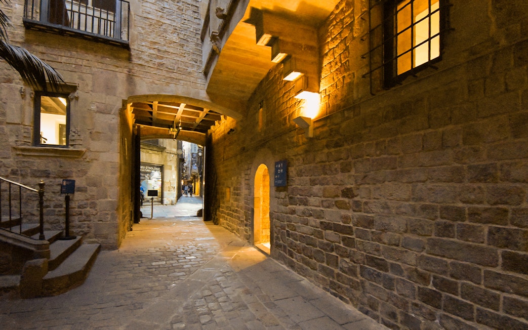 Entrance to the Picasso Museum in Barcelona, featuring a stone archway and cobblestone path.