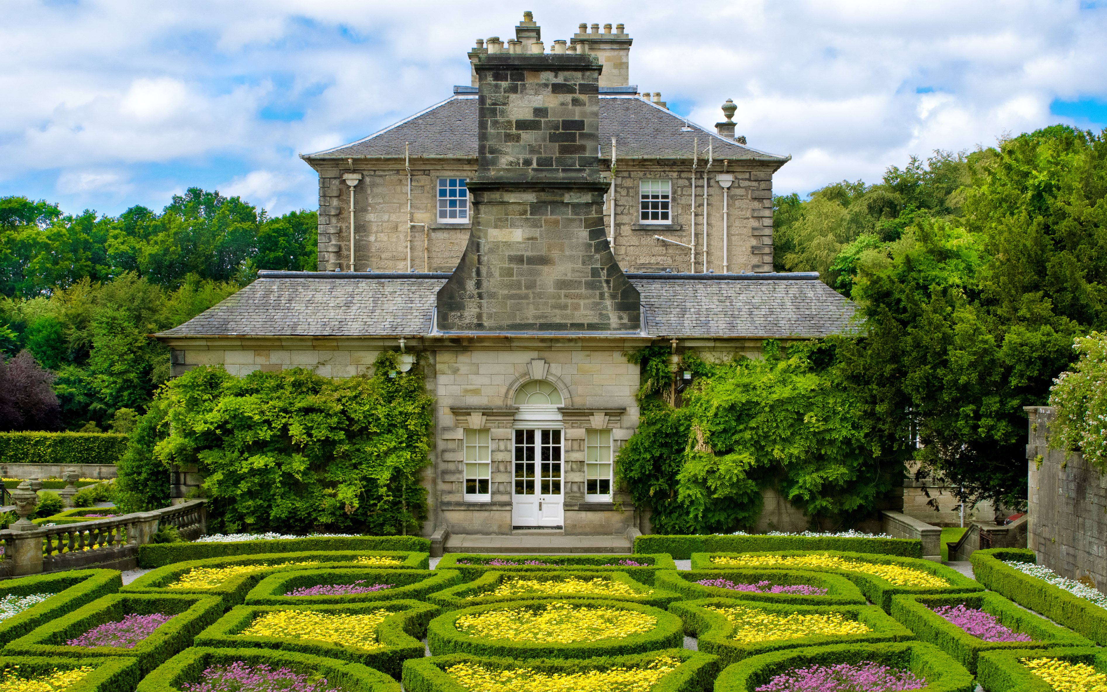 Pollok Country Park garden with historic stone building in Glasgow.