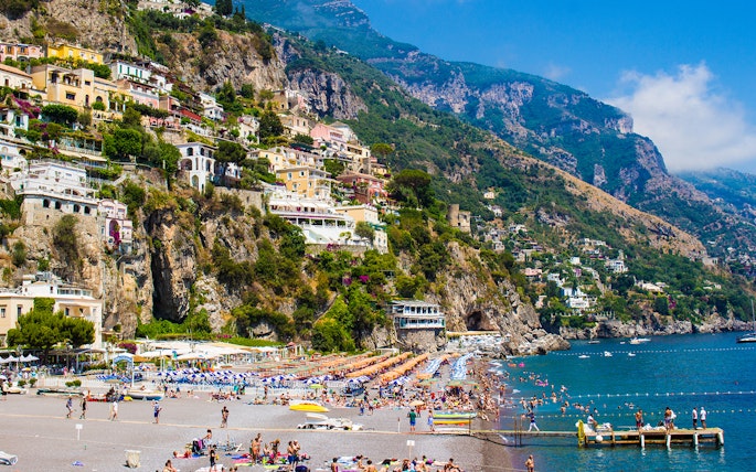 Positano's La Scogliera Beach with colorful umbrellas, part of Rome to Pompeii and Mount Vesuvius tour.