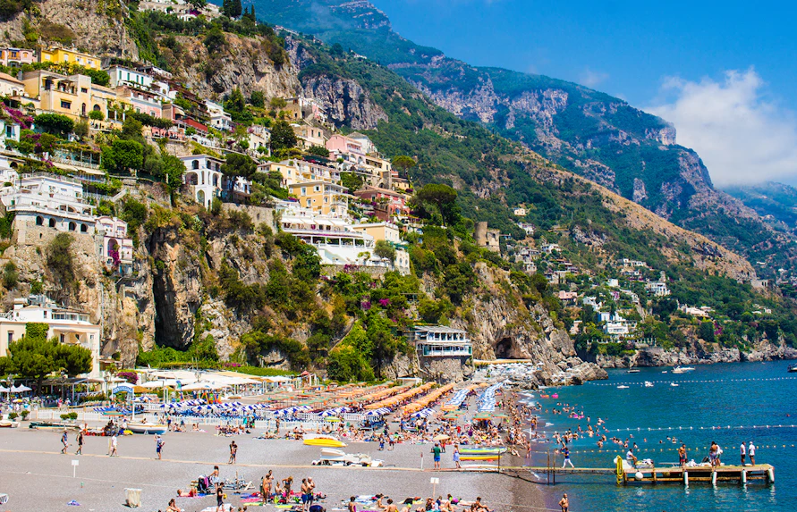 Positano's La Scogliera Beach with colorful umbrellas, part of Rome to Pompeii and Mount Vesuvius tour.