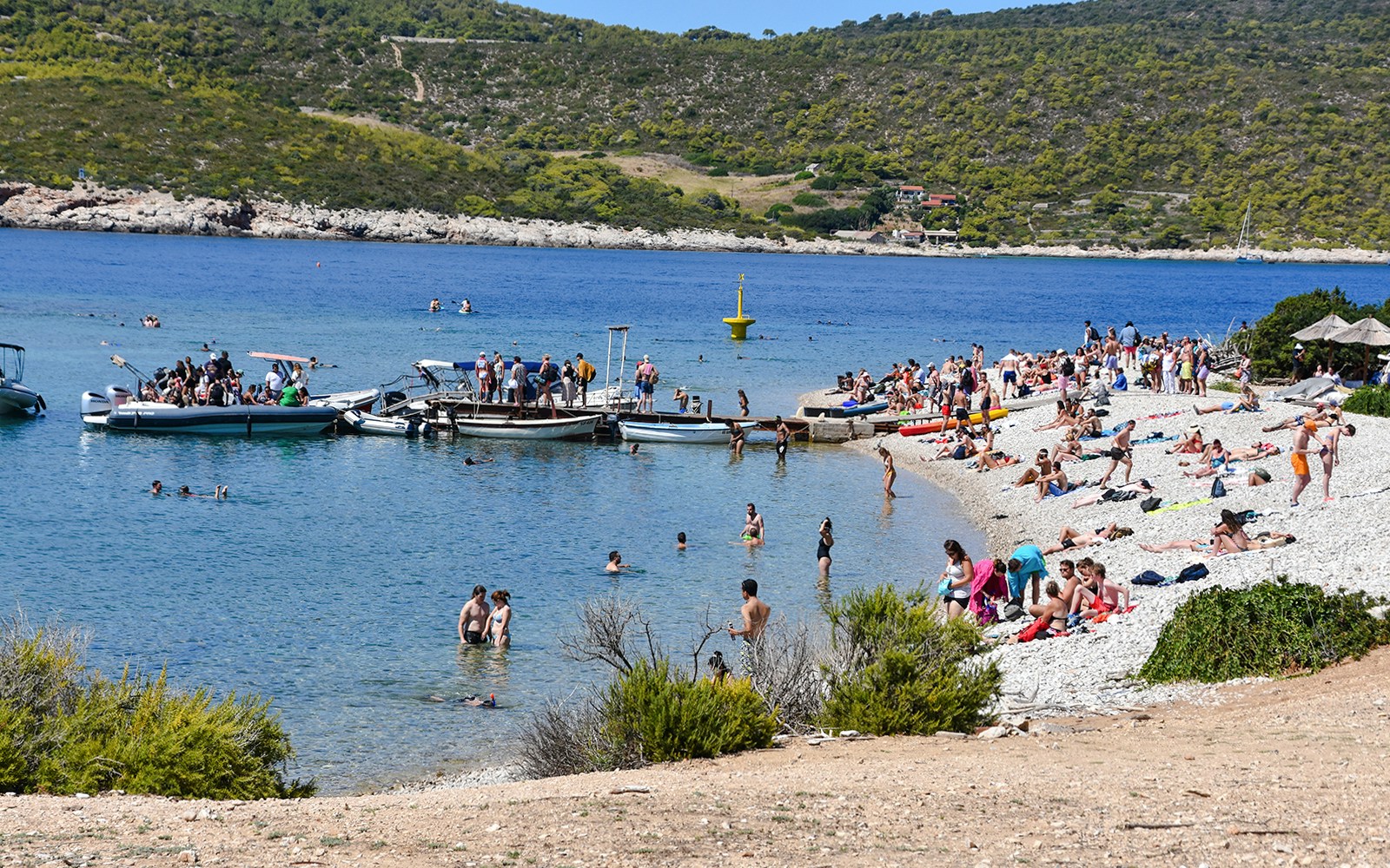 Visitors enjoying the beach and boats at Budikovac Island's Blue Lagoon.