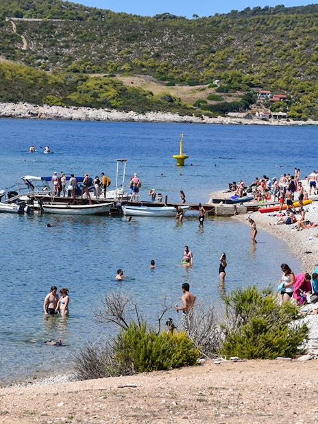 Visitors enjoying the beach and boats at Budikovac Island's Blue Lagoon.