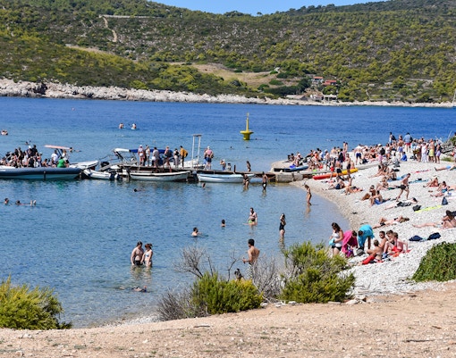 Visitors enjoying the beach and boats at Budikovac Island's Blue Lagoon.